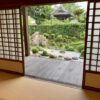 Interior view of a traditional Japanese home with tatami flooring, shoji doors, and an engawa overlooking a garden