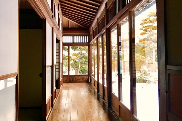 Traditional Japanese engawa with glass panels and interior shoji, showing how layered spaces help regulate sunlight and temperature