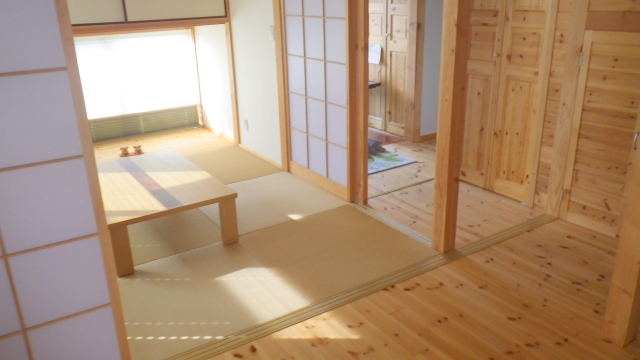A modern washitsu in a Japanese home featuring tatami flooring, shoji screens, sliding doors, and soft natural light creating a calm and flexible living space