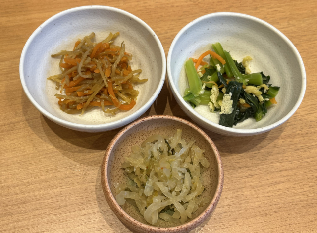 Three small Japanese side dishes, including kinpira burdock, seasoned greens, and pickled vegetables, served as examples of side dishes in an ichiju sansai meal.