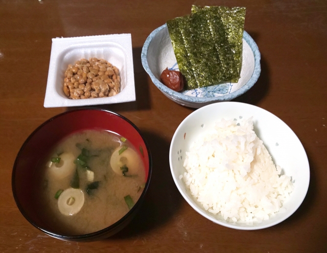 A simple Japanese breakfast with rice, miso soup, natto, nori, and pickled plum, showing a practical everyday morning meal.