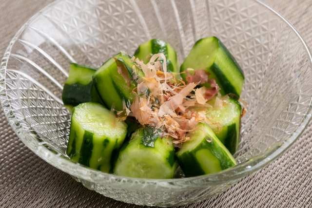 Crisp cucumber asazuke topped with bonito flakes, showing a lightly pickled Japanese vegetable dish.