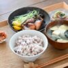 A home-style Japanese ichiju sansai meal with rice, miso soup, grilled fish, and small side dishes, illustrating how separate dishes work together to create a balanced meal.