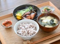 A home-style Japanese ichiju sansai meal with rice, miso soup, grilled fish, and small side dishes, illustrating how separate dishes work together to create a balanced meal.