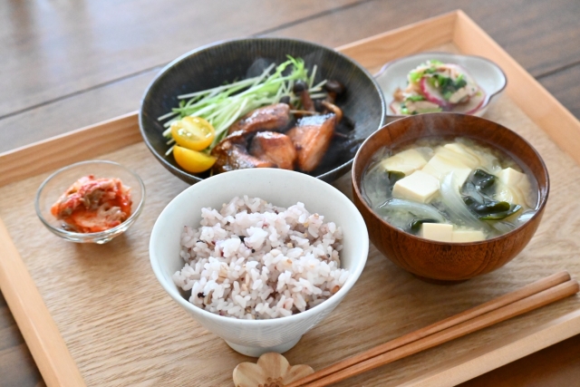 A home-style Japanese ichiju sansai meal with rice, miso soup, grilled fish, and small side dishes, illustrating how separate dishes work together to create a balanced meal.