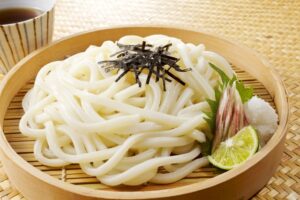 Cold udon noodles topped with shredded nori, showing how thin sheet nori can be cut into strips and used as a garnish.