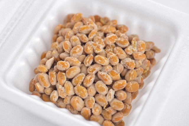 Japanese natto made from fermented whole soybeans in a white container.