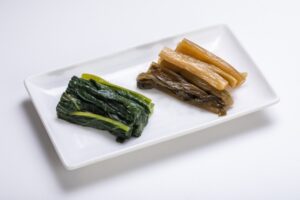 Nozawana pickles served on a small plate, representing a regional Japanese pickling tradition.