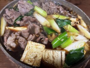 Sukiyaki with grilled tofu, beef, and green onion simmered in a sweet-salty sauce.