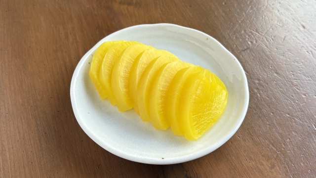 Slices of yellow takuan, a firm pickled daikon commonly served with rice and bento.