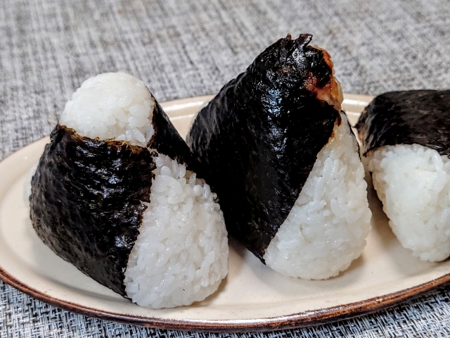 Onigiri rice balls wrapped with nori, showing how nori adds texture, aroma, and a dry outer layer that makes rice easier to hold and eat.