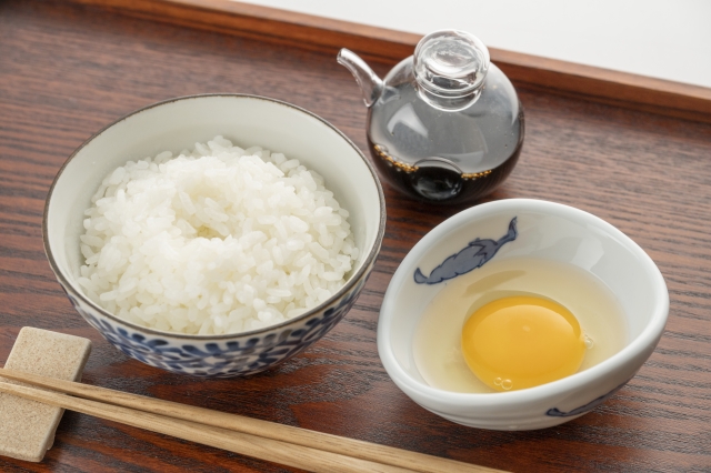 A simple Japanese meal of rice, raw egg, and soy sauce, showing shoyu as an everyday part of the table.