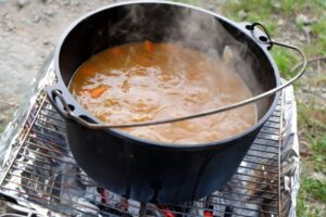 A large pot of Japanese curry cooking outdoors at a camp