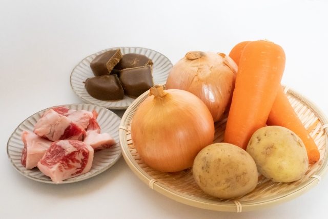 Common ingredients for Japanese curry, including onions, carrots, potatoes, meat, and curry roux