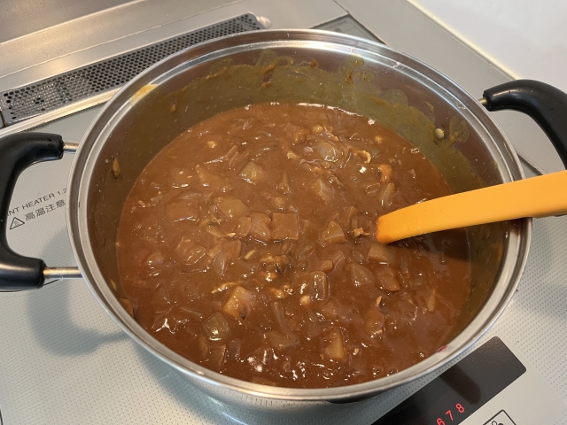 A large pot of homemade Japanese curry simmering on a stovetop
