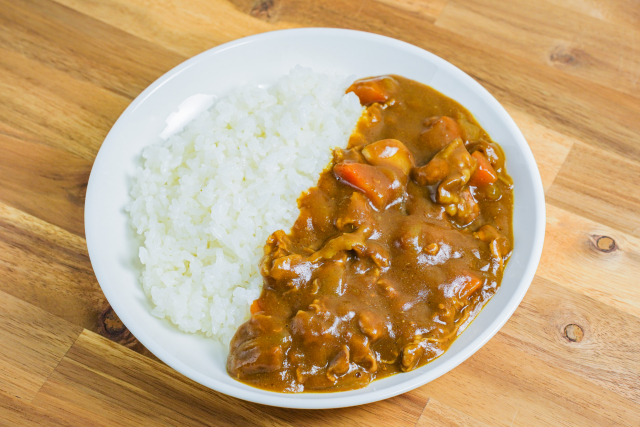 Japanese curry rice with thick brown curry sauce, meat, carrots, and white rice