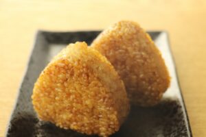 Grilled rice balls with a toasted surface, a savory pairing for hojicha