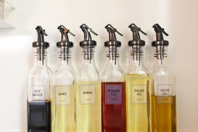 Soy sauce, sake, mirin, and cooking oils lined up in a Japanese kitchen
