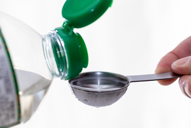 Japanese cooking sake being poured into a measuring spoon