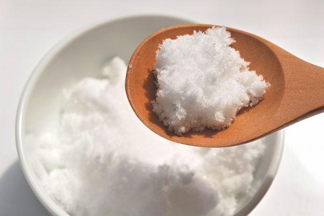 Soft, fine Japanese jōhakutō white sugar piled on a wooden spoon above a bowl