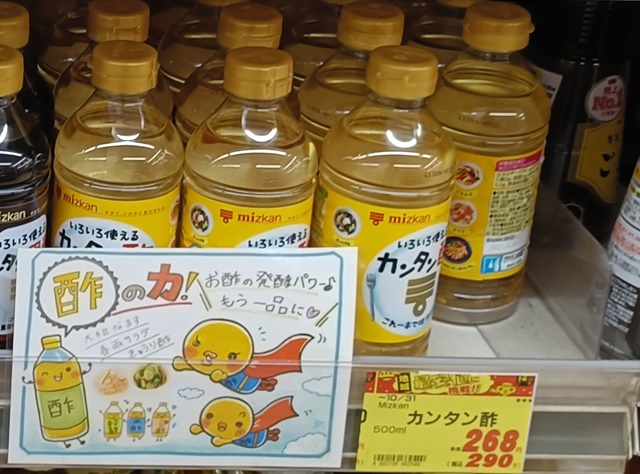 Mizkan Kantan Su seasoned vinegar bottles displayed behind a promotional sign in a Japanese supermarket.