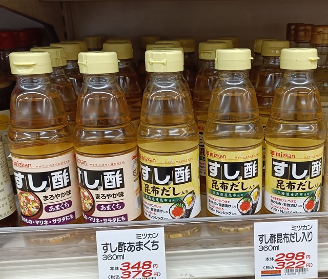Mizkan sushi vinegar bottles, including a kombu dashi-flavored variety, displayed in a Japanese supermarket.