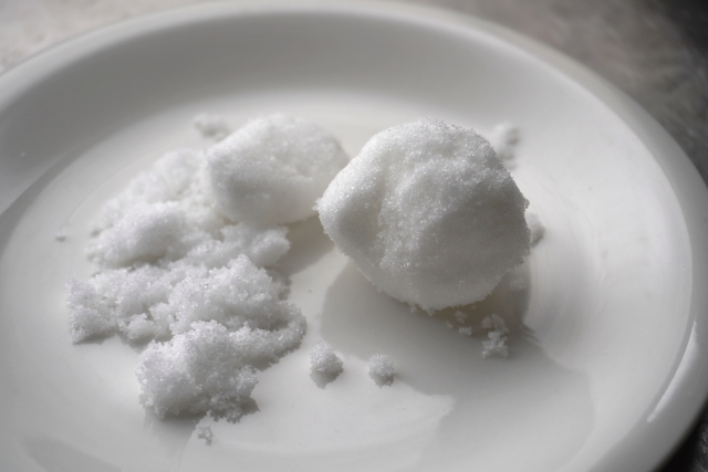 Lumps of Japanese jōhakutō white sugar on a white plate