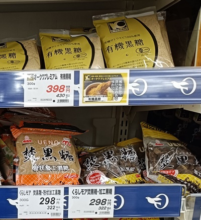Packages of Japanese kokutō black sugar and processed black sugar displayed on supermarket shelves
