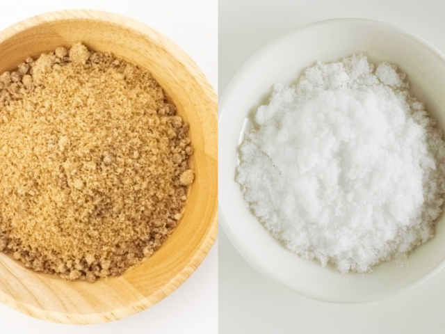 Japanese kokutō black sugar in a wooden bowl beside white jōhakutō sugar in a ceramic bowl