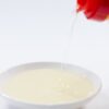 Golden mirin being poured into a small white dish