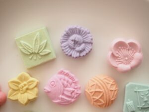 Pastel-colored Japanese higashi sweets made with wasanbon sugar, shaped like flowers, a fish, and traditional patterns