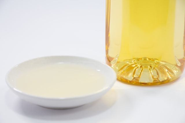 Hon mirin in a small white dish beside a bottle of golden mirin